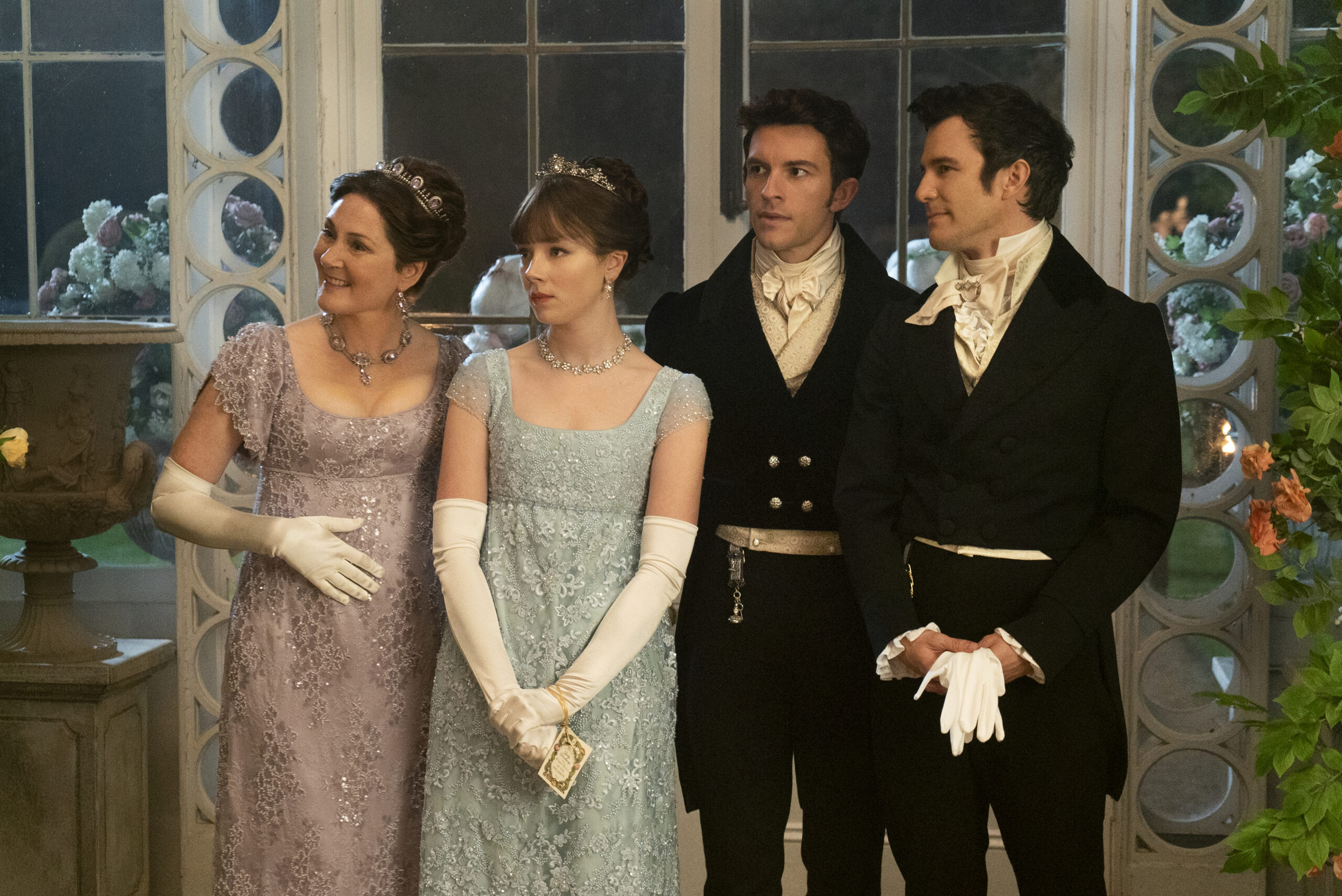 Ruth Gemmell as Lady Violet Bridgerton, Claudia Jessie as Eloise Bridgerton, Jonathan Bailey as Anthony Bridgerton, and Luke Thomspon as Benedict Bridgerton in episode 201 of Bridgerton.