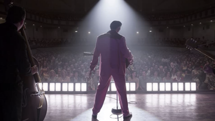 Elvis Presley standing in front of a sold out audience