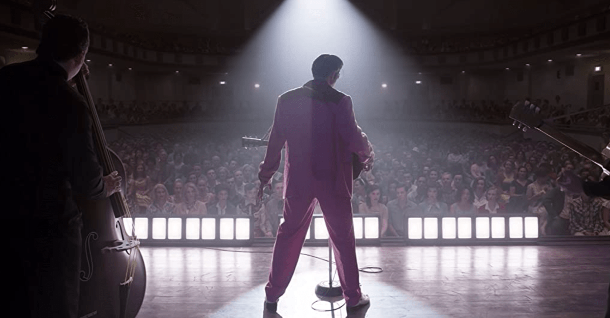 Elvis Presley standing in front of a sold out audience