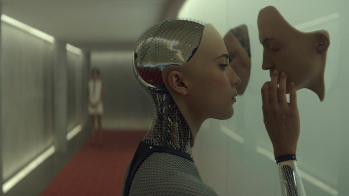Ava tests the limits of her self-awareness by examining another face, in Ex Machina.