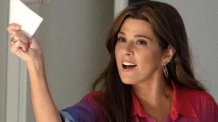 Marisa Tomei as Aunt May holding a piece of paper
