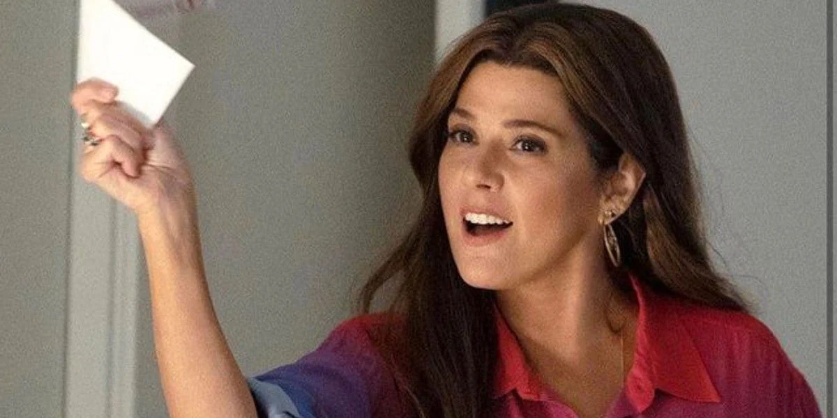 Marisa Tomei as Aunt May holding a piece of paper