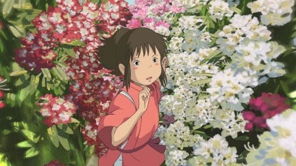 A screenshot from Studio Ghibli's Spirited Away featuring the protagonist, Chihiro, running through a tunnel of flowers.