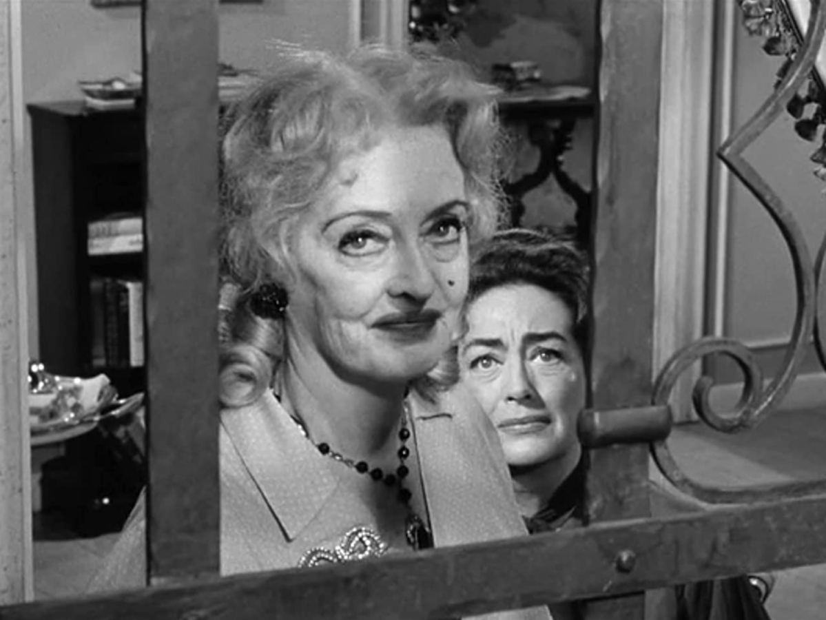 Joan Crawford peaks over Bette Davis's shoulder in Whatever Happened to Baby Jane