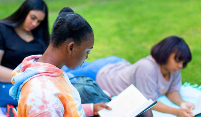 Three Black and brown girls reading. (Image: Nappy.co user @childrennaturenetwork.) SOURCE: https://nappy.co/photo/3073/children-and-nature