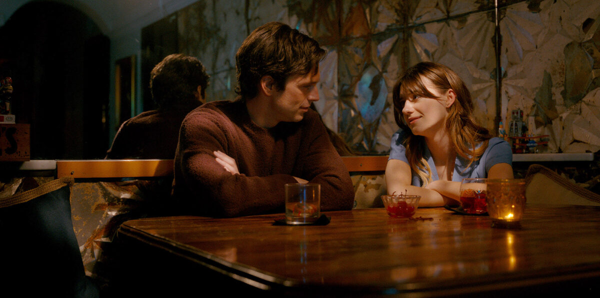 Sebastian Stan and Daisy Edgar-Jones are seated at a table in Fresh
