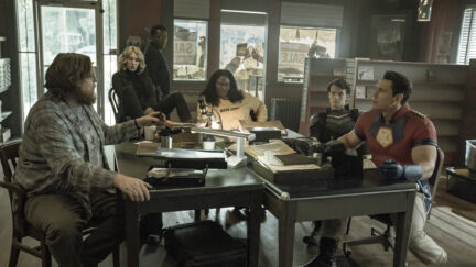 The team sitting together at a table on Peacemaker