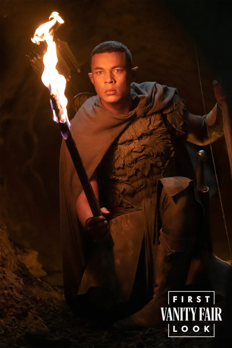 Ismael Cruz Córdova as the silvan Elf Arondir, holding his sword and a torch. 