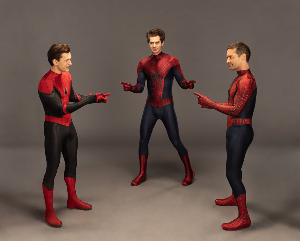 Tom Holland zeigt auf Andrew Garfield und tobey Maguire, alle in ihren Spider-Man-Kostümen