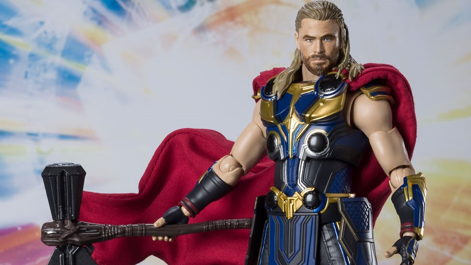An action figure of Thor, wearing blue and gold armor and holding Stormbreaker.