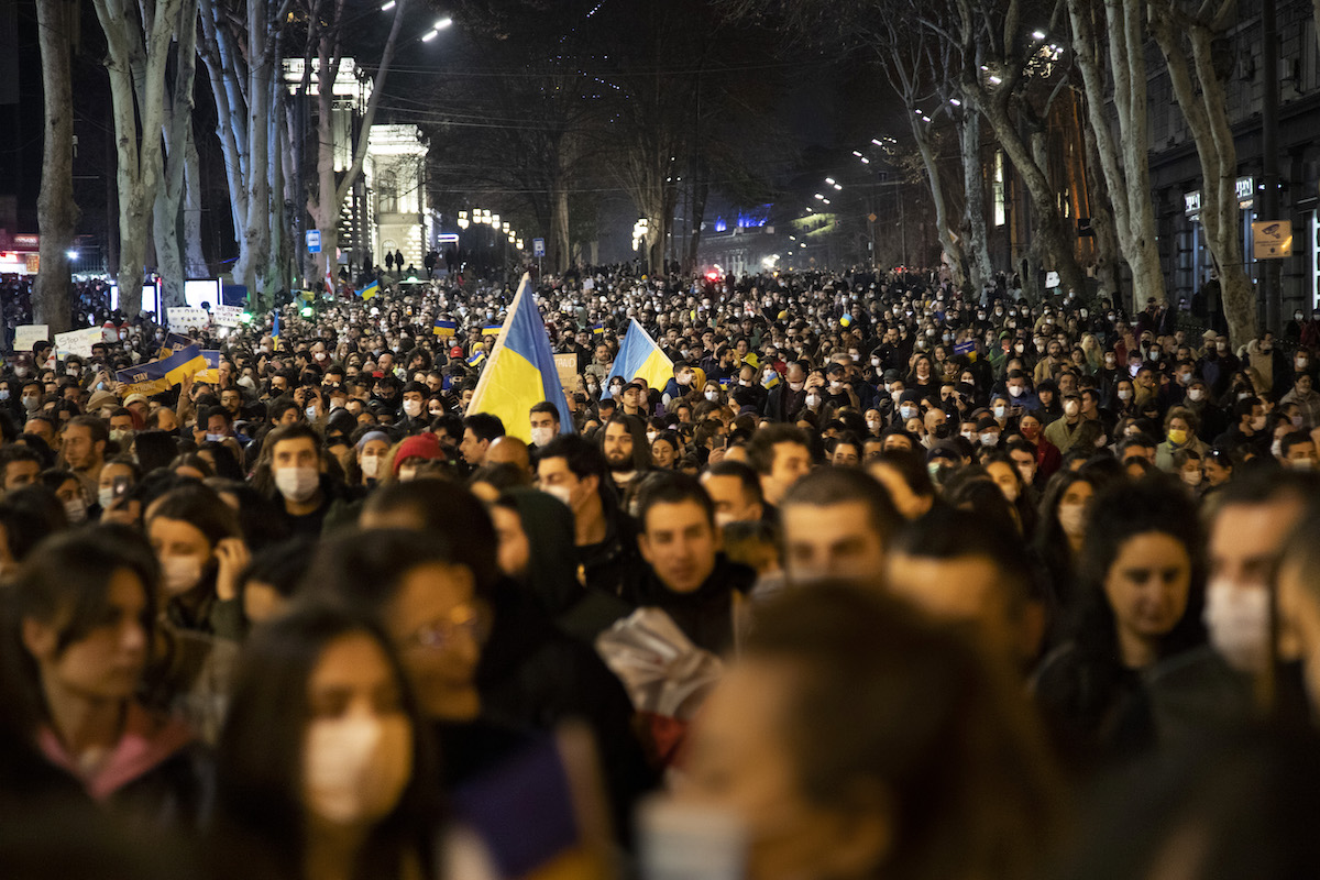 A large crowd of people marches in a pro-Ukraine protest.