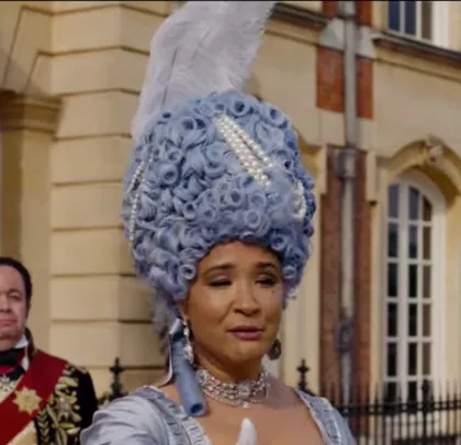 Queen Charlotte Wears a blue wig with pearls.