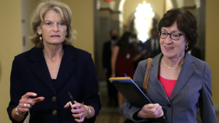 Lisa Murkowski and Susan Collins walk together in a Capitol hallway.