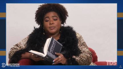 Dulcé Sloan reading Indigo by Beverly Jenkins. (Image: The Daily Show with Trevor Noah.)