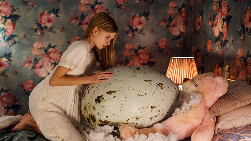 Tinja cradles a giant egg in her frilly pink bedroom.