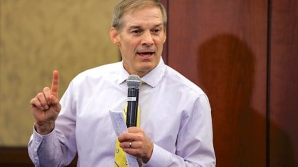 Jim Jordan holds a microphone and speaks during a town hall meeting.