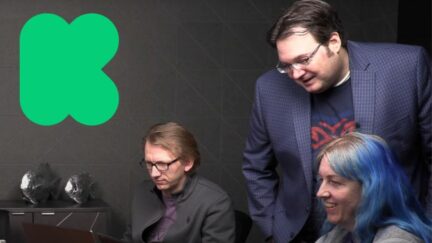 Sanderson and friends looking at a computer. Kickstarter (K) logo. Image: screencap and Kickstarter. https://youtu.be/TVdZ018gsRw