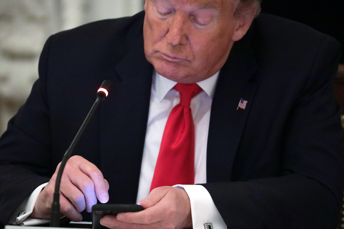Donald Trump frowns while looking at his cell phone