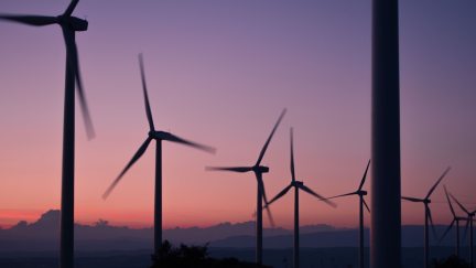 A silhouette of wind turbines at sunset.