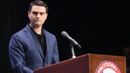 Ben Shapiro looks irritated standing at a podium.