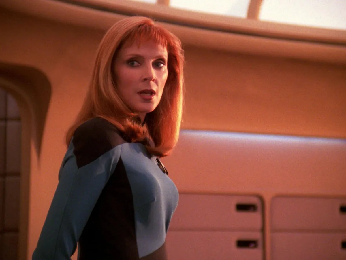 Gates McFadden as Dr Beverly Crusher, standing on the bridge of the Enterprise.