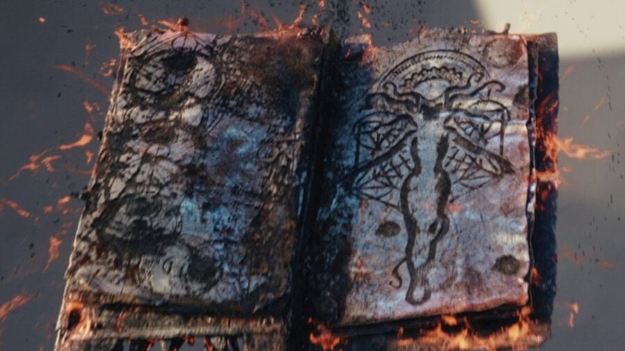 The Darkhold, an ancient spellbook, is open to an illustration of the Scarlet Witch. Flames surround the pages.