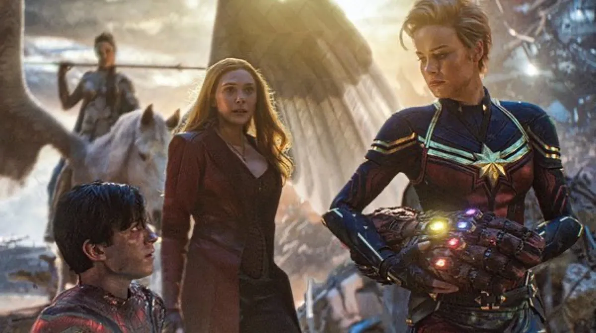 Captain Marvel taking the Infinity Gauntlet from Spider-Man as Scarlet Witch and Valkyrie look on in Marvel's Avengers: Endgame.