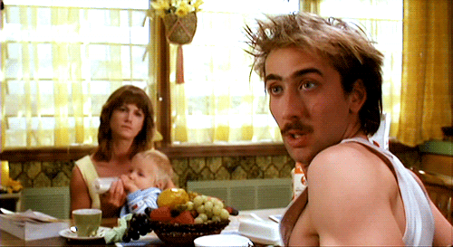 Nic Cage at the table with Holly Hunter blinking