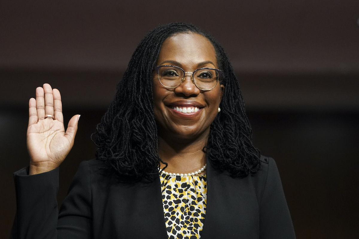 Ketanji Brown Jackson raises her right hand and grins as she's sworn in