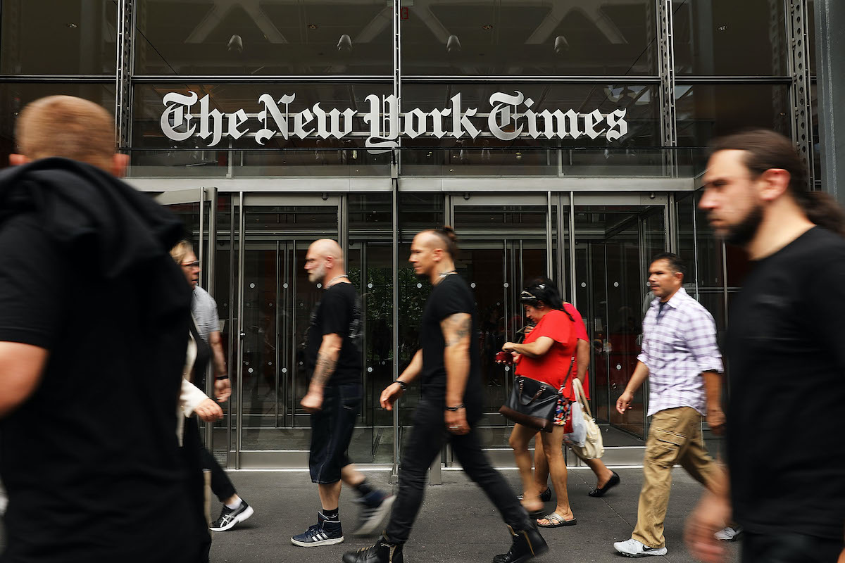 Pedestrians walk in front of the New York Times office building.