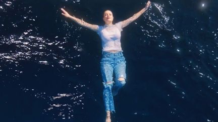 Heidi Montag floating in the ocean with a white shirt and blue jeans. Image: Oceana and S1ngles.