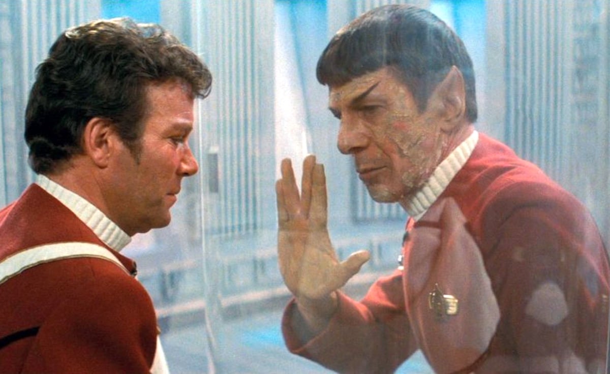 Kirk e Spock separados por vidro e Spock dão a ele a saudação da vulcânica em