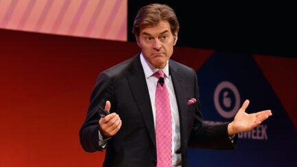 Dr Oz shrugs on stage at an event.