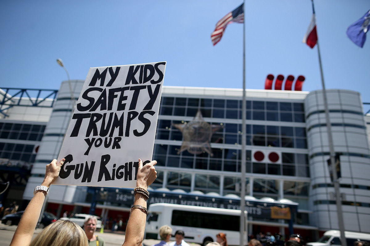 A sign says my kids safety trumps your gun rights at a protest