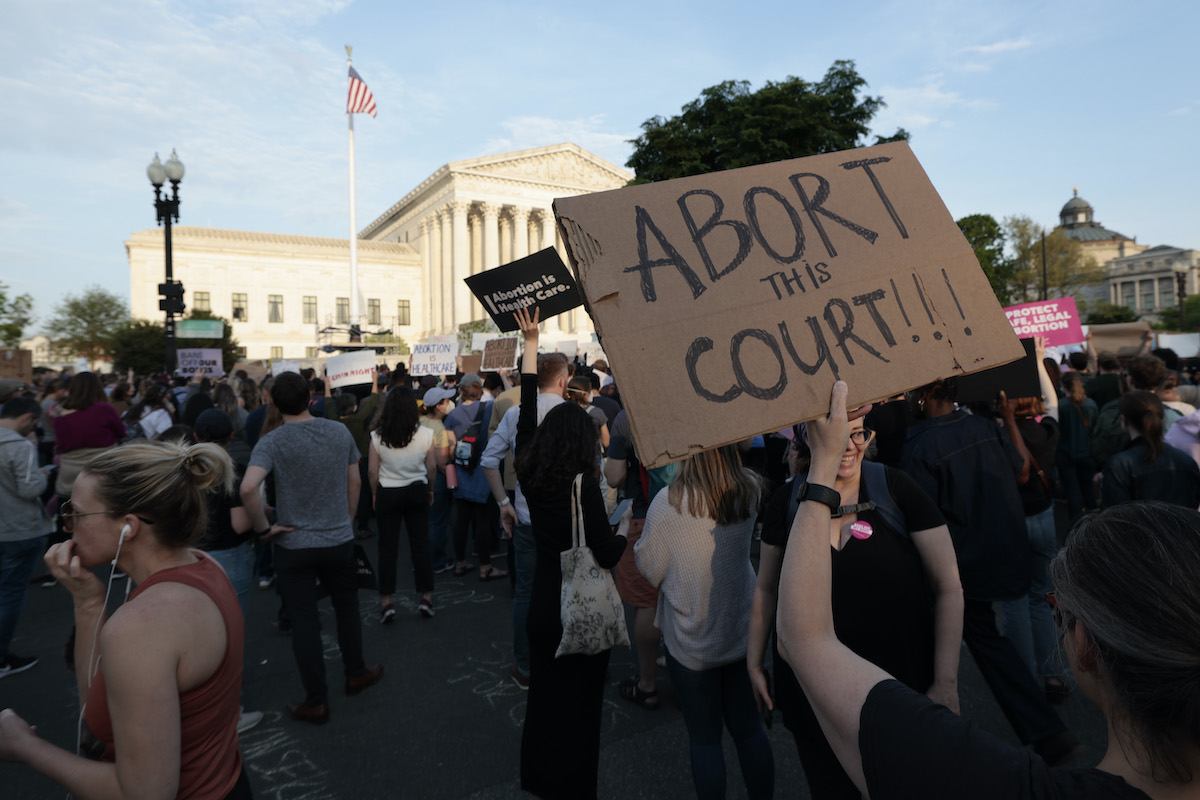 Protesters gather outside the supreme court building holding pro-choice and anti-scotus signs.