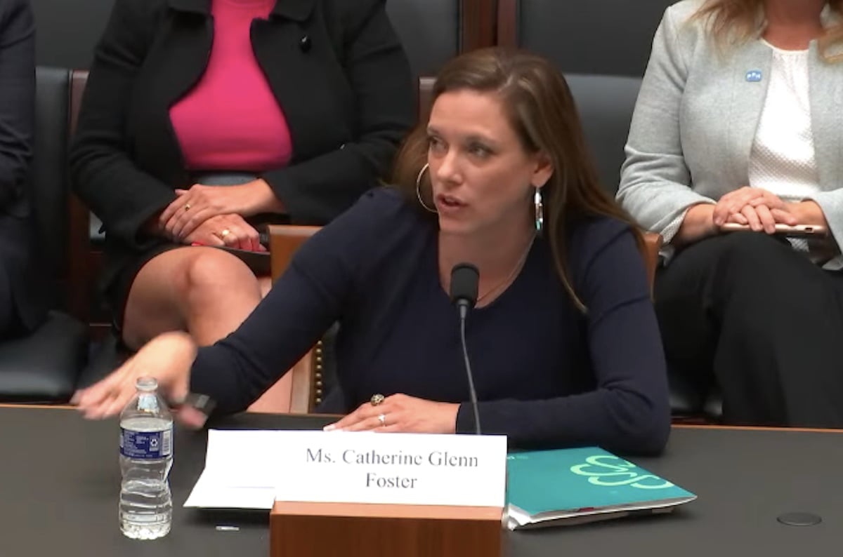 A white woman testifies before congress, looking irritated