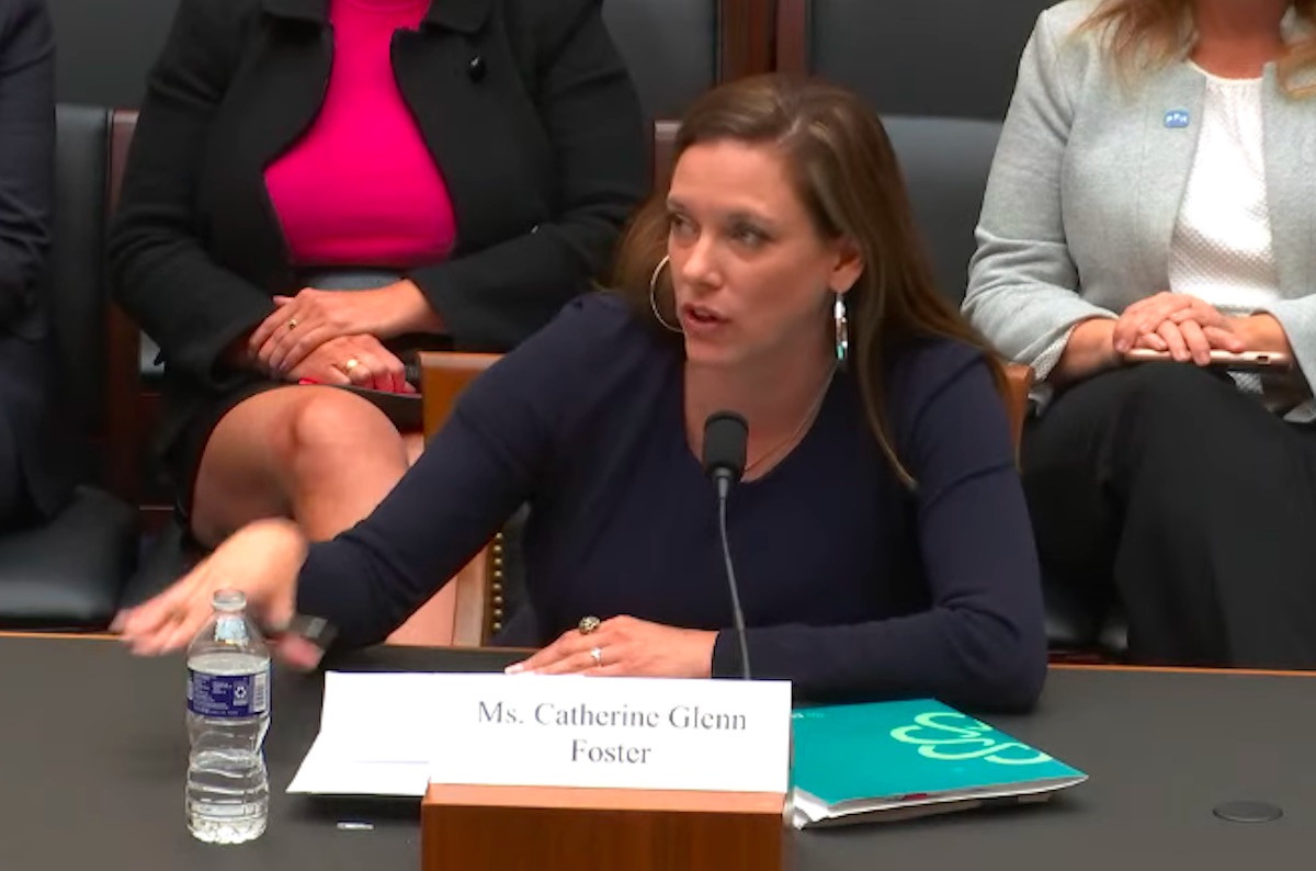 A white woman testifies before congress, looking irritated