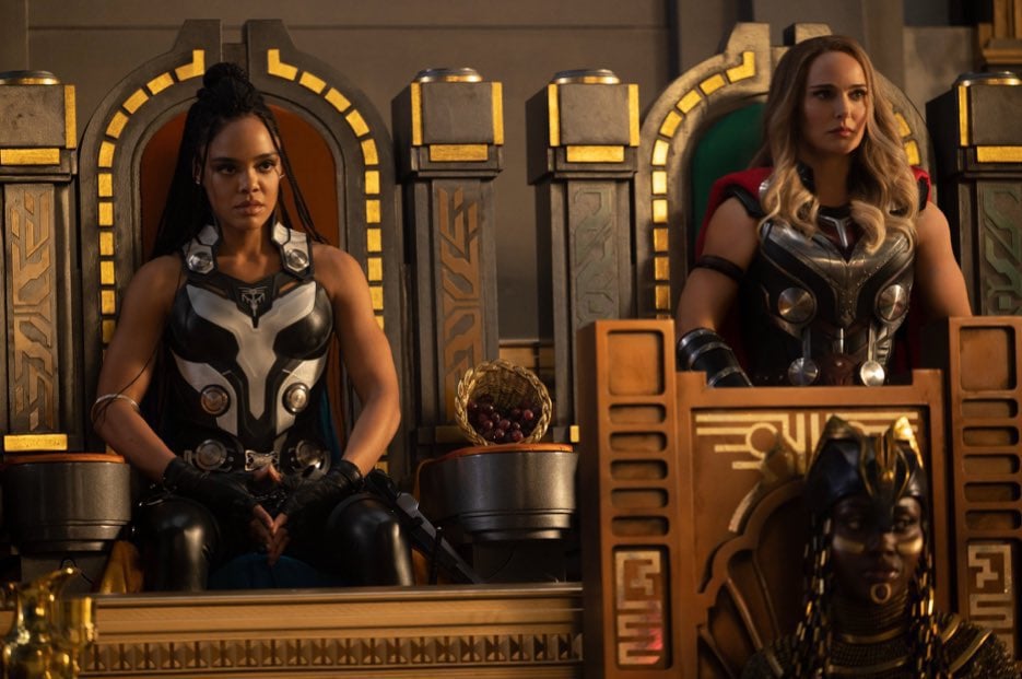 Valkyrie (Tessa Thompson), Jane Foster as the Mighty Thor (Natalie Portman), and Bast (Akosia Sabet) sit in thrones.
