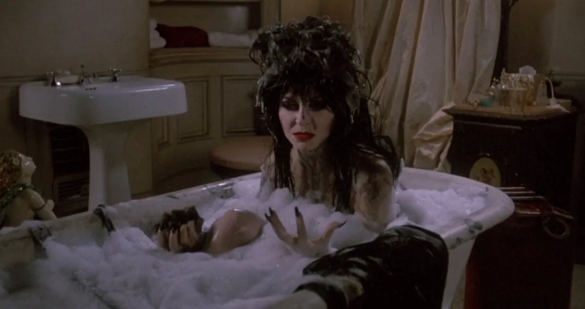 Elvira bathing in Elvira: Mistress of the Dark