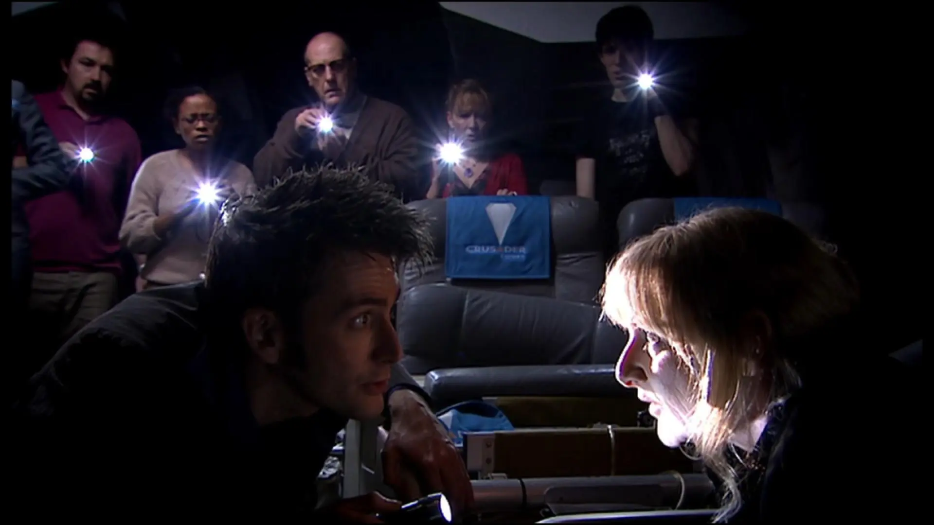 The Doctor looking into a possessed passenger's face in a ship on Doctor Who.