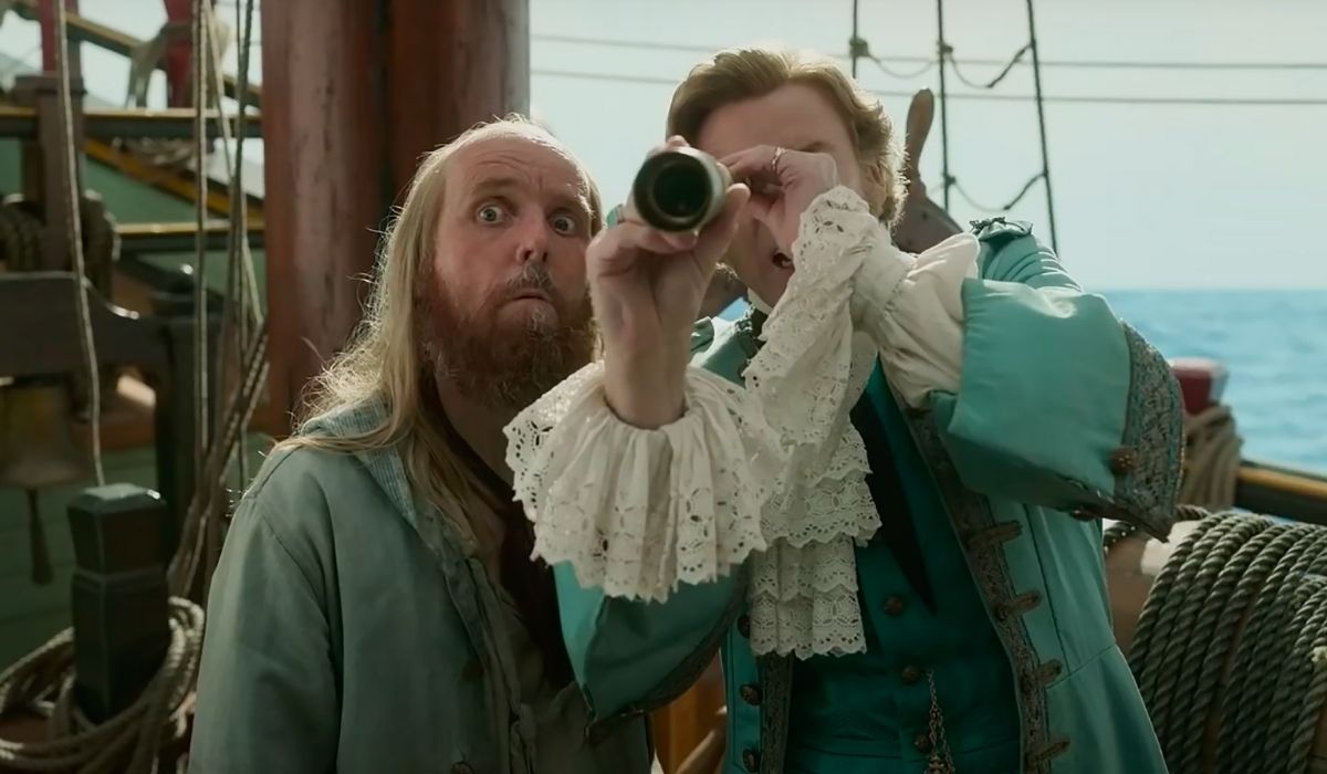Ewen Bremner as Nathaniel Buttons looking out next to Rhys Darby as Stede Bonnet.