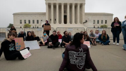 A group of pro-choice protesters sit gathered outside the US Supreme Court