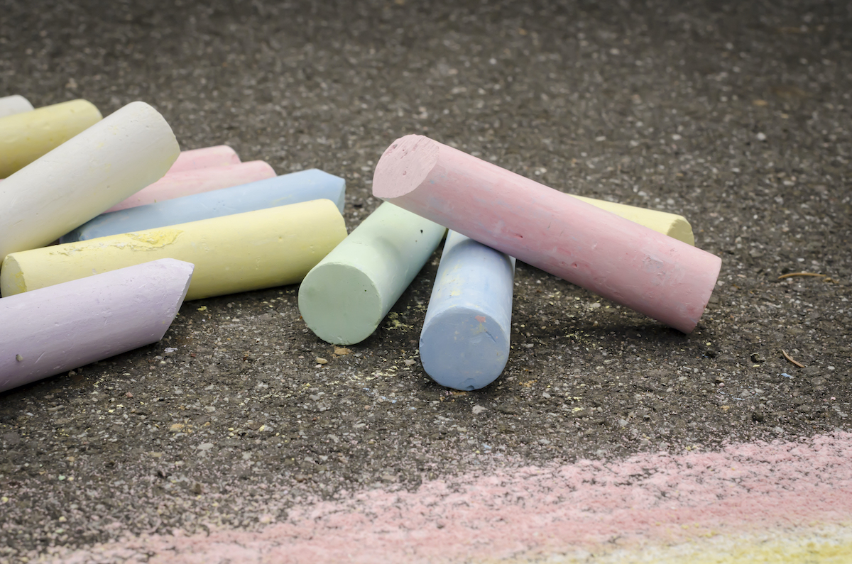 Colored chalk on asphalt lying.