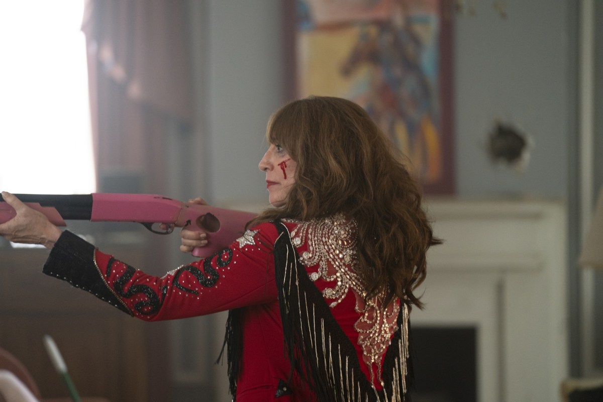 Harper Dutch with a bloodied face, wielding a shot gun