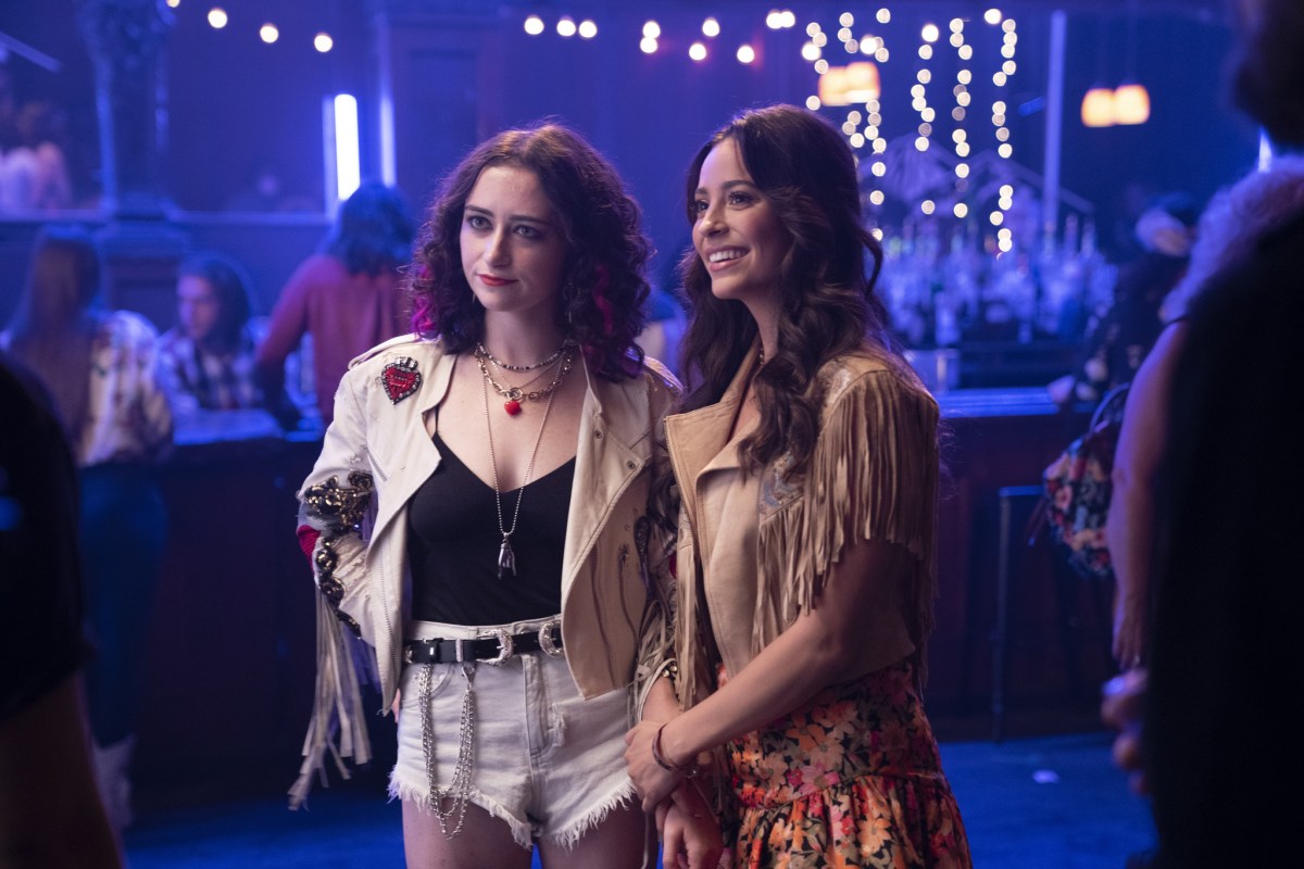 Jordan Wilder and Leigh Blackhouse stand side by side in a crowded bar