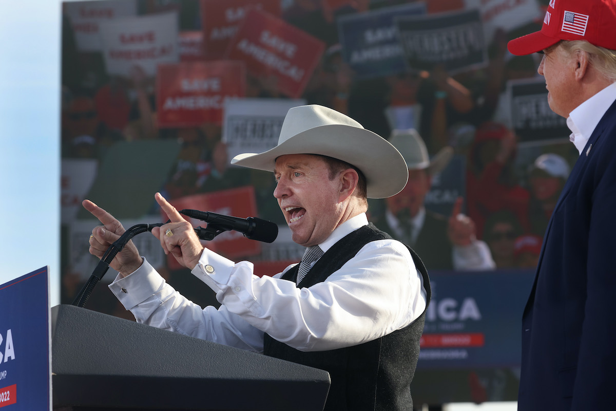 Donald Trump watches as a white man in a cowboy hat (Charles Herbster) speaks during a rally
