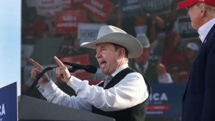 Donald Trump watches as a white man in a cowboy hat (Charles Herbster) speaks during a rally