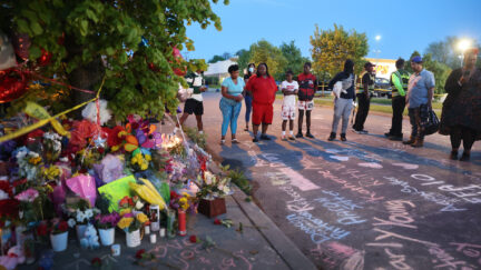 Names of victims and messages of healing are chalked on the ground at a makeshift memorial outside of Tops market