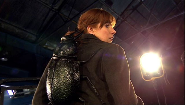 Donna looking at a monster on her back in Doctor Who.