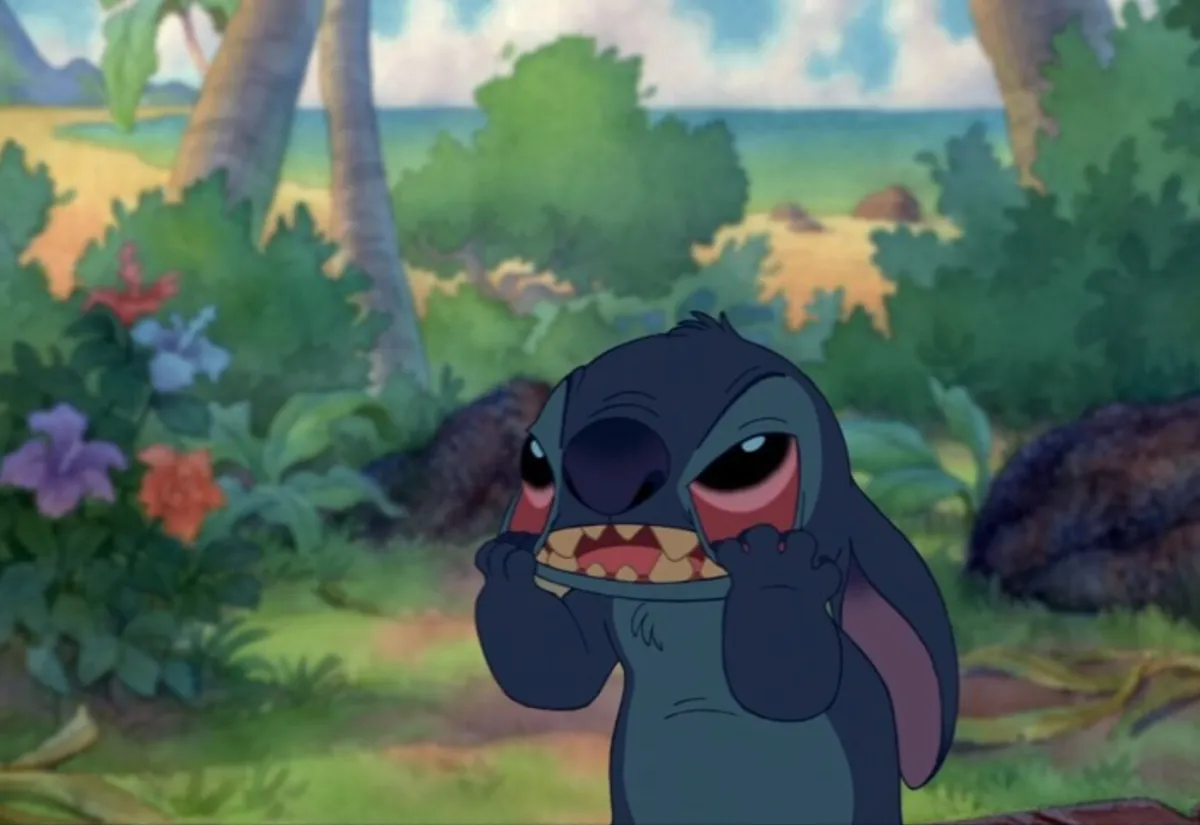 Stitch from Lilo & Stitch dragging the skin from the bottom of his eyes out of frustration. Image: Disney.